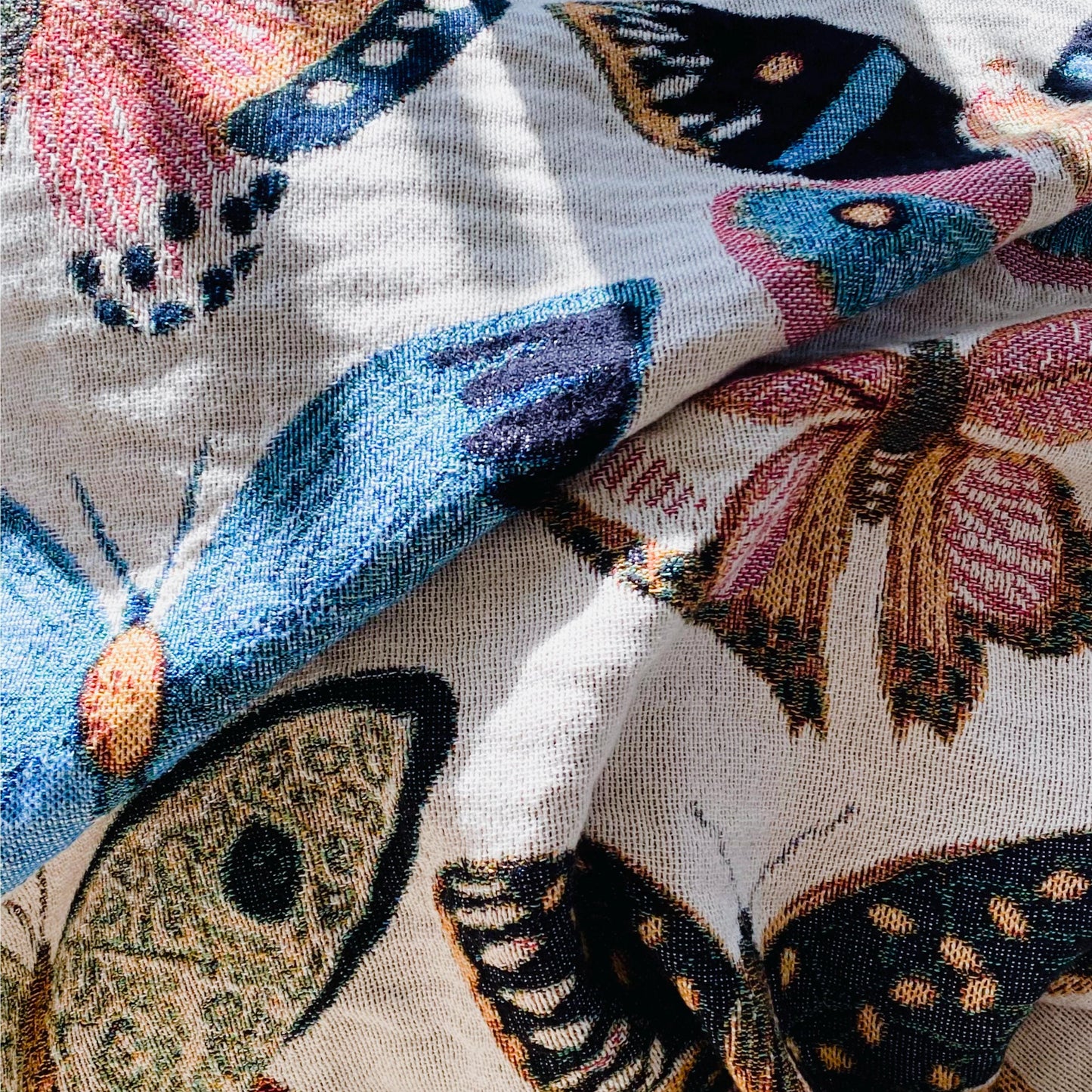 Cozy woven throw blanket with vibrant hand-illustrated butterflies. Brings joyful colors and charm to nurseries, dorms, and reading nooks.