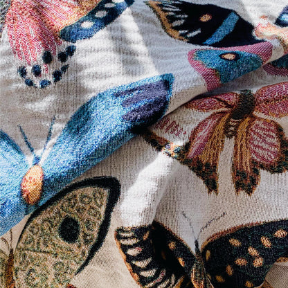 Cozy woven throw blanket with vibrant hand-illustrated butterflies. Brings joyful colors and charm to nurseries, dorms, and reading nooks.