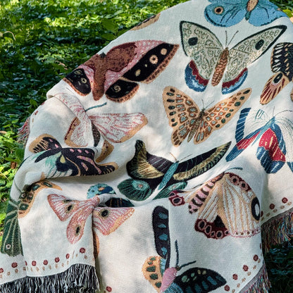 Cozy woven throw blanket with vibrant hand-illustrated butterflies. Brings joyful colors and charm to nurseries, dorms, and reading nooks.
