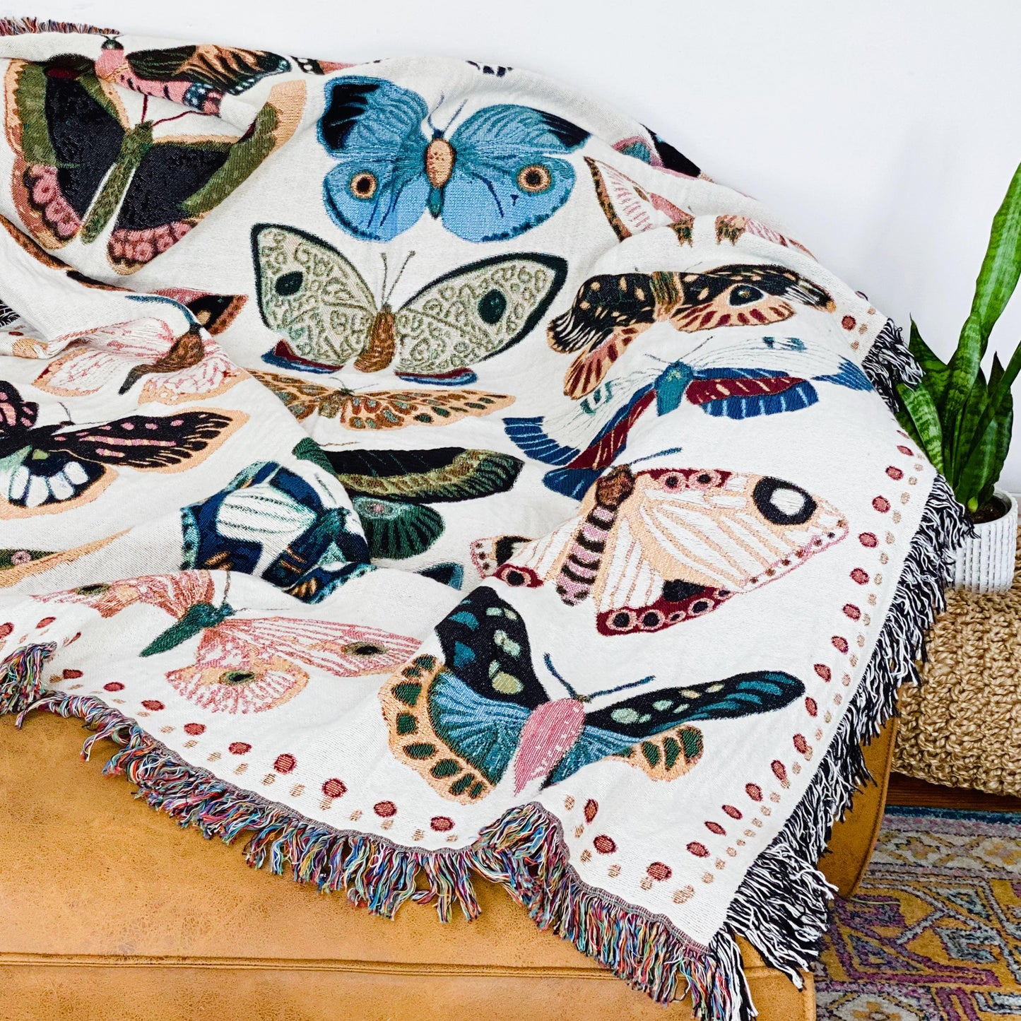Cozy woven throw blanket with vibrant hand-illustrated butterflies. Brings joyful colors and charm to nurseries, dorms, and reading nooks.