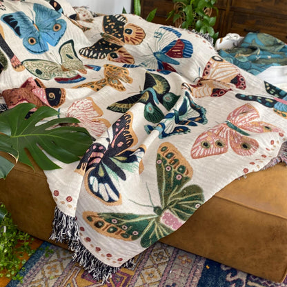 Cozy woven throw blanket with vibrant hand-illustrated butterflies. Brings joyful colors and charm to nurseries, dorms, and reading nooks.