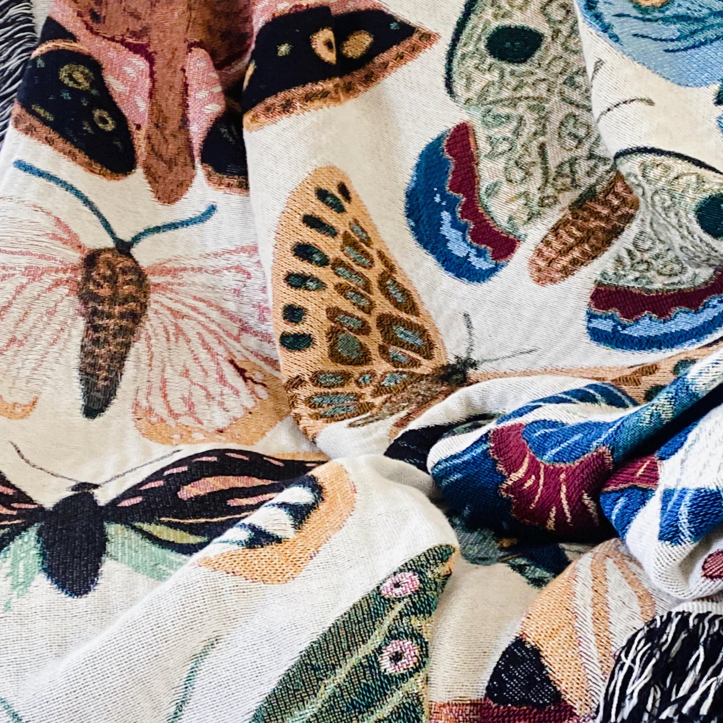 Cozy woven throw blanket with vibrant hand-illustrated butterflies. Brings joyful colors and charm to nurseries, dorms, and reading nooks.